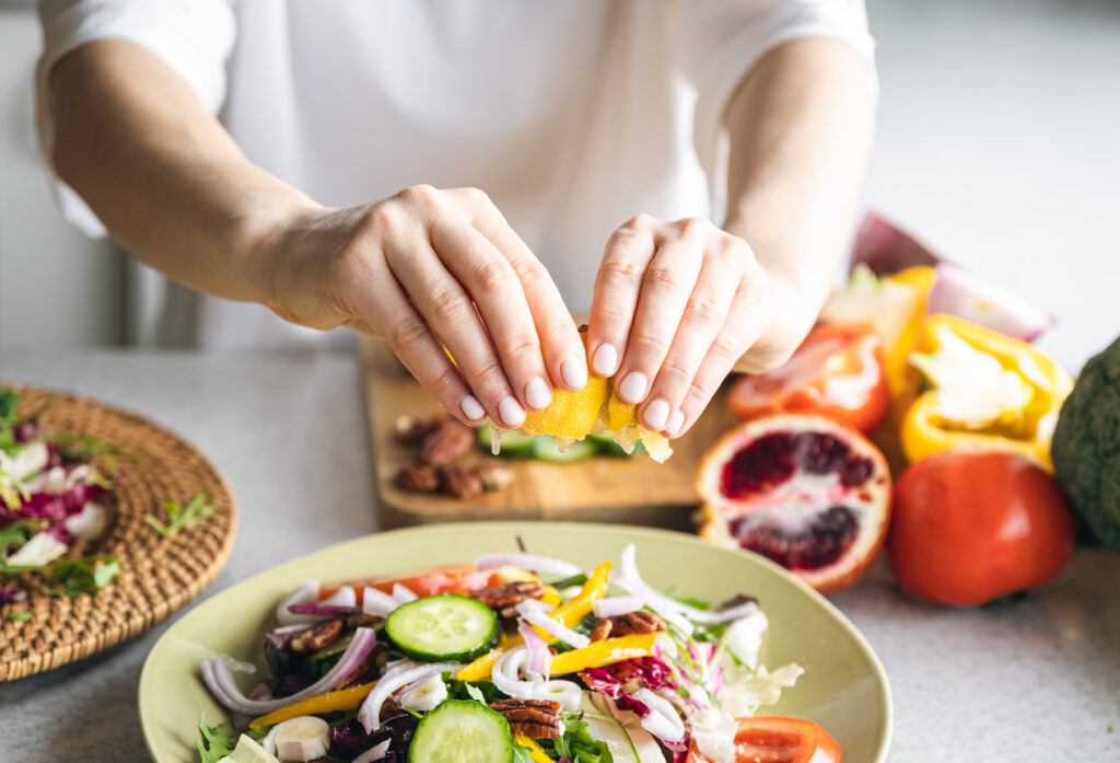 a woman makes a fresh vegetable salad, close up.
